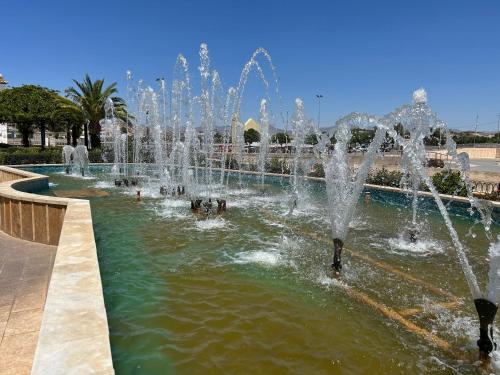 a fountain in a pool with people in the water at Casa Mica in Albox