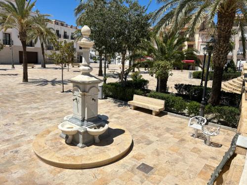 a fountain in the middle of a park with a bench at Casa Mica in Albox