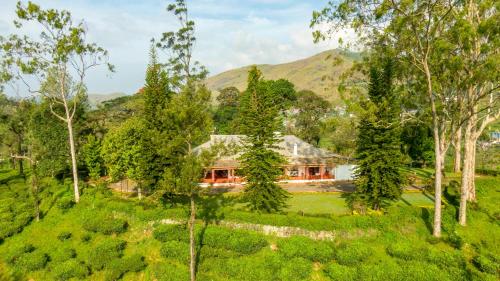 an aerial view of a house in the middle of a forest at Sinna Dorai's Rotti Kadai Bungalow in Vālpārai