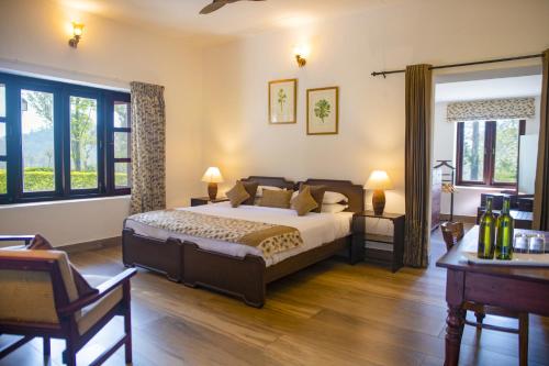 a bedroom with a bed and two tables and windows at Sinna Dorai's Rotti Kadai Bungalow in Vālpārai
