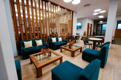 a lobby with blue couches and chairs and tables at HOTEL ARENALES in San Fernando del Valle de Catamarca