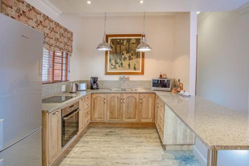 a kitchen with wooden cabinets and a counter top at Leaves Lodge and Spa in Nelspruit