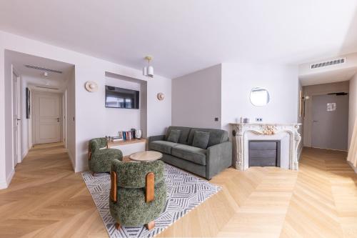 a living room with a couch and chairs and a fireplace at Quartier Libre Opera in Paris