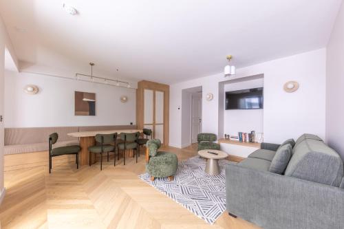 a living room with a couch and a table and chairs at Quartier Libre Opera in Paris