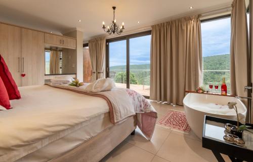 a bedroom with a large bed and a tub and a sink at Alkantmooi Private Nature Reserve - Keurkloof & Keurbos 93 in Plettenberg Bay