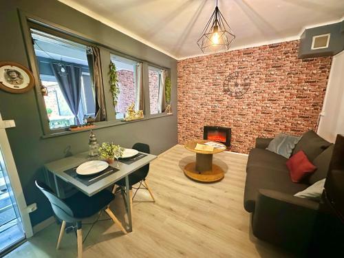 - un salon avec un canapé, une table et une cheminée dans l'établissement Le Charbon Doré, Train Lens - Paris trajet d'environ 1 heure 10 minutes, à Lens