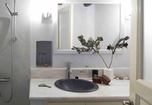 Cheerful 2-bedroom villa with gorgeous terraces في هيدرا: طاولة حمام مع حوض ومرآة