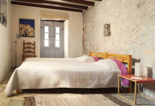 Cheerful 2-bedroom villa with gorgeous terraces في هيدرا: غرفة نوم بها سرير كبير وطاولة