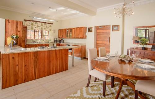 a kitchen with wooden cabinets and a wooden table at Leaves Lodge and Spa in Nelspruit