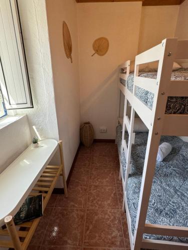 a small room with two bunk beds and a window at Encanto de Xisto in Piódão