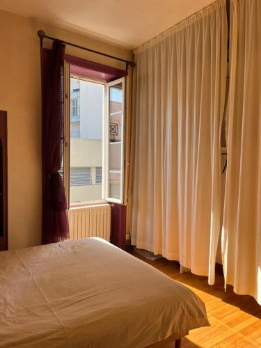 une chambre avec un lit et une grande fenêtre dans l'établissement Bisson, à Les Sables-dʼOlonne