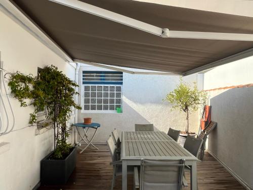 un patio avec une table, des chaises et une fenêtre dans l'établissement Bisson, à Les Sables-dʼOlonne