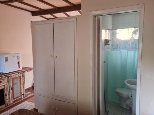 a bathroom with a white cabinet and a toilet at Willa Hala in Vinhedo