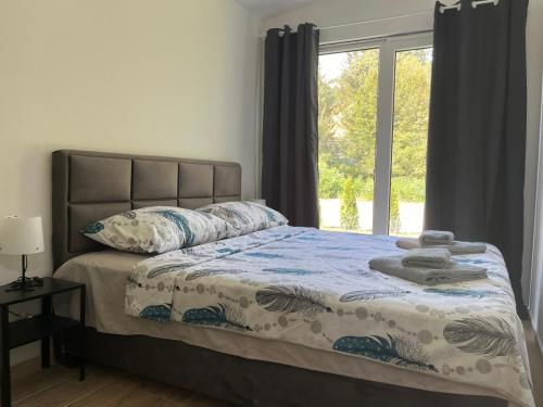 a bedroom with a bed with a large window at HARIZMA LUX Banja Vrujci in Popadić