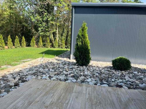 a garden with rocks and trees and a building at HARIZMA LUX Banja Vrujci in Popadić
