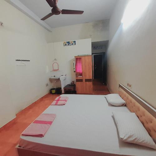 a large white bed in a room with a ceiling at Shree jayadurga boarding&lodging in Udupi