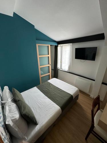 a bedroom with a bed with a blue wall at Hôtel Flor Rivoli in Paris