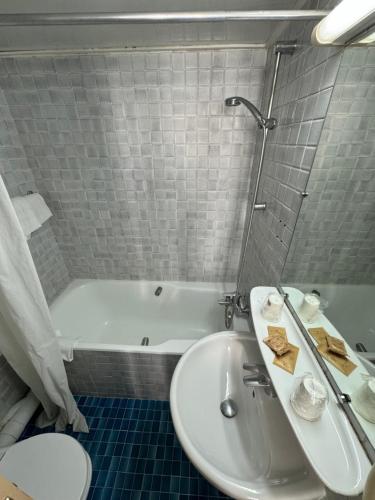 a bathroom with a sink and a bath tub at Hôtel Flor Rivoli in Paris