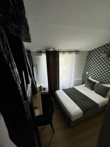a hotel room with a bed and a window at Hôtel Flor Rivoli in Paris