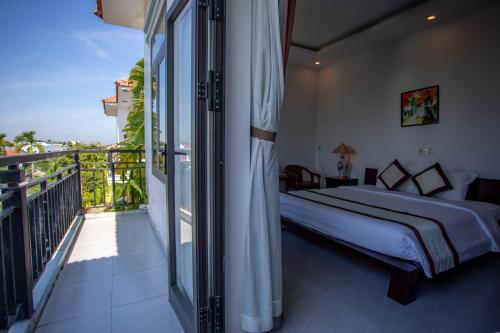 a bedroom with a bed and a balcony at Hoi An Fairy Garden Villa in Hoi An