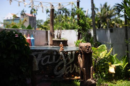 a statue in front of a fountain in a garden at Hoi An Fairy Garden Villa in Hoi An