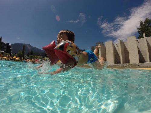 a young child is in a swimming pool at Apartaments Giberga in LʼAldosa