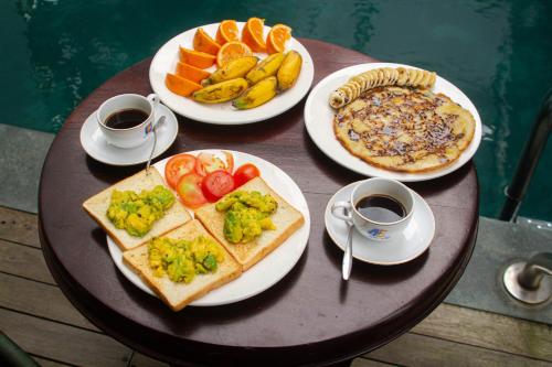a table with plates of food and two cups of coffee at Hoi An Fairy Garden Villa in Hoi An