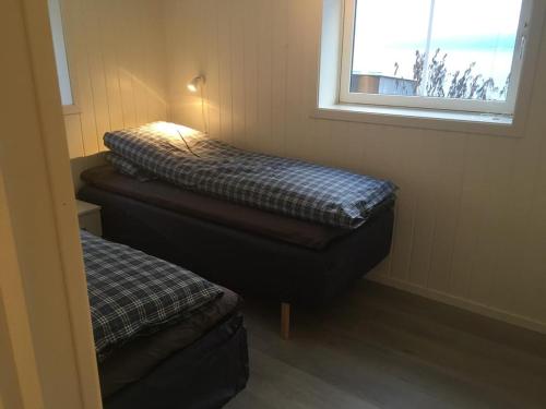 a small room with two beds and a window at Lyngen Brygge in Årøybukta