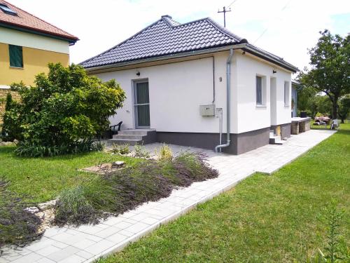 a small white house with a grass yard at апартаменты Sоlо in Hévíz