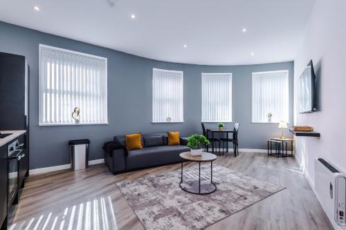 a living room with a couch and a table at The Seven Suites Liverpool in Liverpool