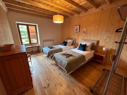 deux lits dans une chambre aux murs en bois dans l'établissement Oisans Vacances Gîte Rose Quartz, à Allemont