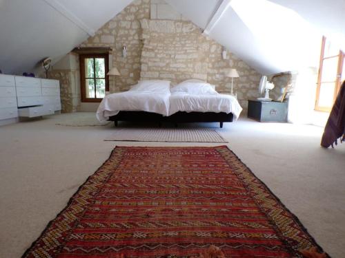 une chambre avec un lit et un tapis au sol dans l'établissement Gîte forestier Les Pipistrelles, à Sazilly