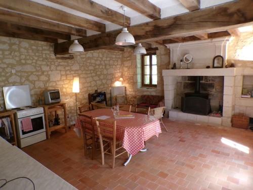 un salon avec une table et une cheminée dans l'établissement Gîte forestier Les Pipistrelles, à Sazilly