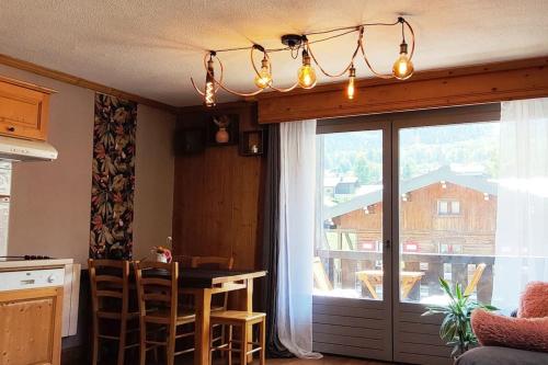 une cuisine avec une table et une grande fenêtre dans l'établissement Appartement vue Montblanc 5mn piste2, à Les Trabets