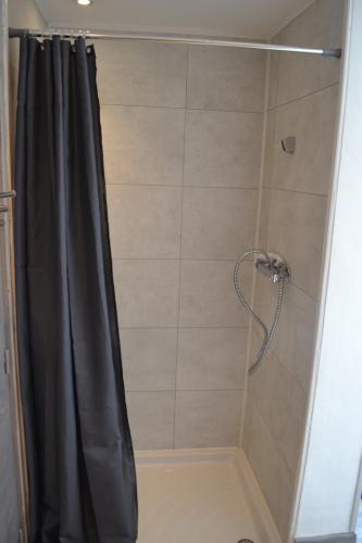 La salle de bains est pourvue d'une douche avec rideau de douche noir. dans l'établissement Chez Véronique et Jean Daniel, à Maubec