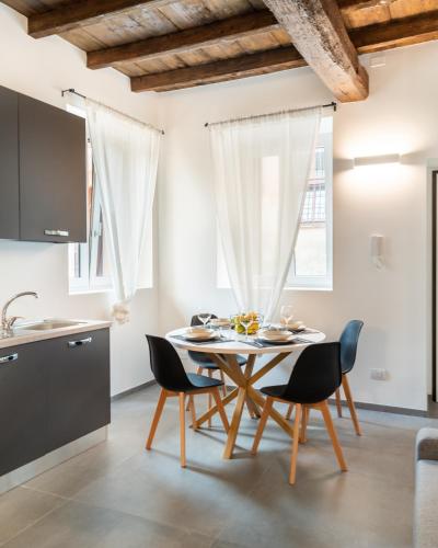 a kitchen and dining room with a table and chairs at Naviglio suite apartments in Robecco sul Naviglio