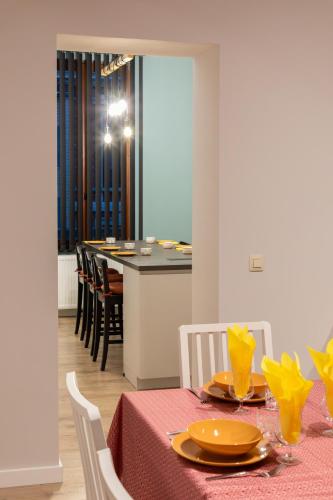 a dining room with a table and a kitchen at Gîte touristique Vivaccueil Binche in Binche