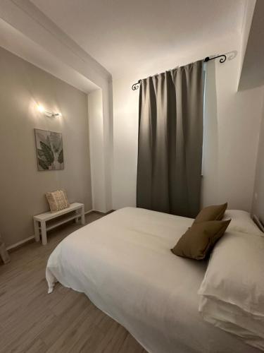 Un dormitorio con una gran cama blanca con una cortina. en L'Angolo Rosa, en Casale Monferrato