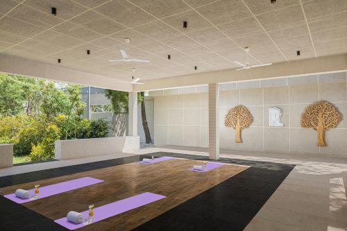 乌代浦Essentia Luxury Resort & Spa Udaipur的瑜伽室,地板上配有紫色垫