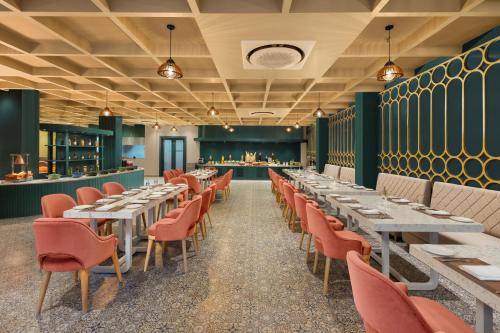 a dining room with tables and chairs and a bar at Essentia Luxury Resort & Spa Udaipur in Udaipur