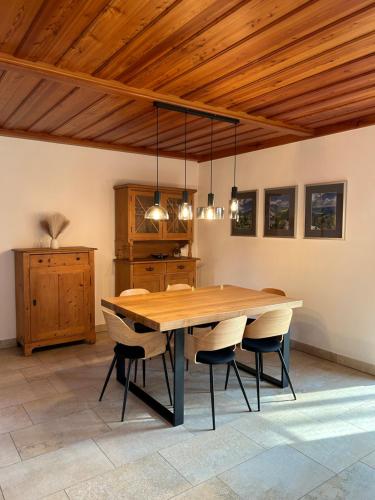 a dining room with a wooden table and chairs at Ferienhaus an der Drau in Sankt Oswald