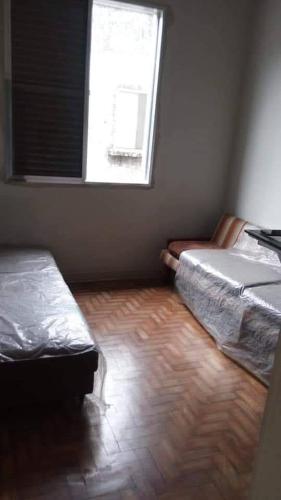 a bedroom with two beds and a window at Apartamento porta da praia - Ocian in Samaritá