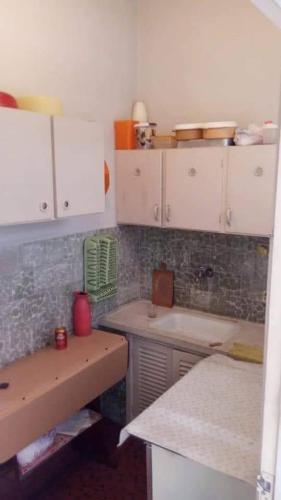 a kitchen with white cabinets and a sink at Apartamento porta da praia - Ocian in Samaritá