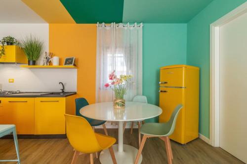 a kitchen with a table and yellow chairs at CASA ALLEGRA appartamento in centro Palmanova in Palmanova