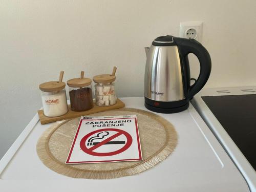 a no parking sign on a counter next to a coffee pot at Apartman Nikka in Bihać