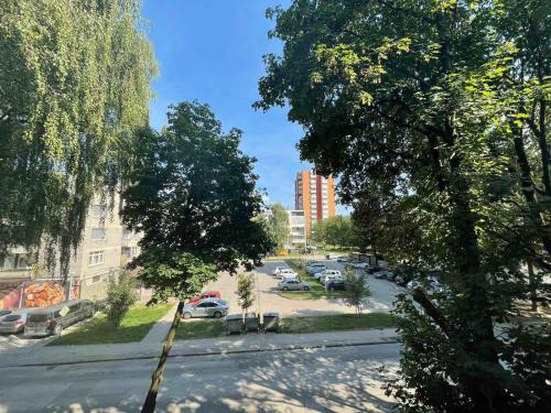 a city street with cars parked in a parking lot at Apartman Nikka in Bihać