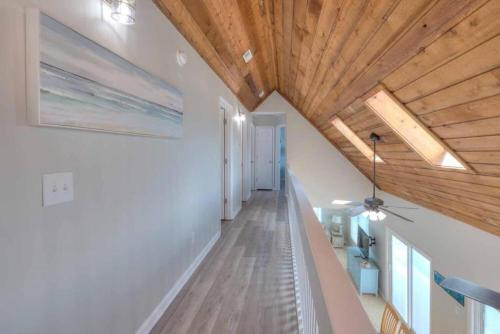 a hallway with white walls and wooden ceilings at Dune Alright in Oak Island