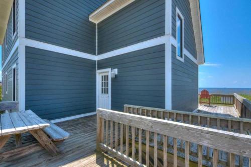 a porch of a house with a bench on it at Dune Alright in Oak Island