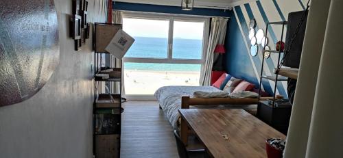 een slaapkamer met een bed en uitzicht op het strand bij Appart n°22, VUE MER, Plage in Perros-Guirec