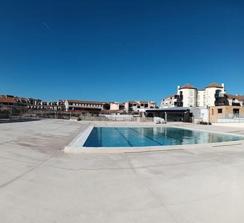 une piscine vide avec des bâtiments en arrière-plan dans l'établissement Appartement avec vue magnifique sur le lac marin, au Barcarès